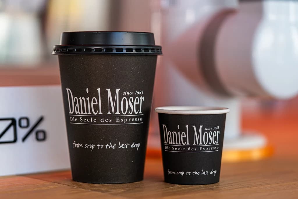 Daniel Moser branded coffee cups on the counter