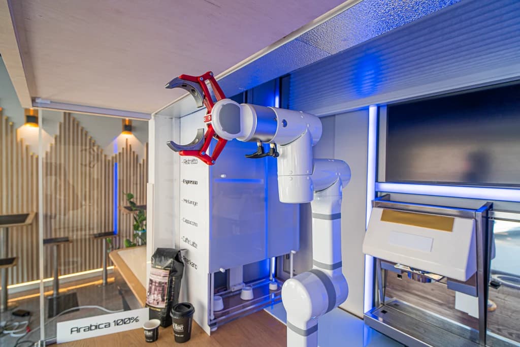 Robot barista arm at its station with blue ambient lighting